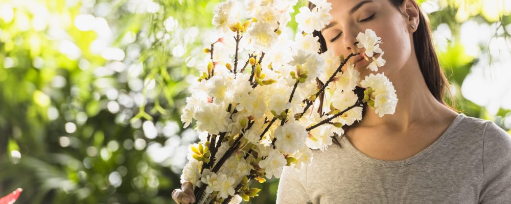 attractive-woman-holding-bunch-flower-twigs-near-face